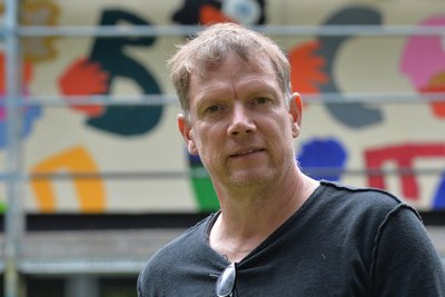 Künstler Michael Fischer-Art 2022 vor der Fassade des Förderzentrums „Käthe Kollwitz“ Freiberg.