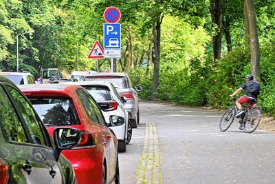 Einer der offiziellen Radrouten am Schloßteich führt zur Schloßteichstraße. Dort parkende Autos erschweren Radfahrern das Ein- und Ausfahren – sie weichen auf Parkwege aus.