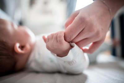 Ein Baby klammert sich an den Finger seiner Mutter: 2024 sind im Erzgebirge 1280 Babys zur Welt gekommen.
