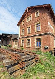 Hinter dem Bahnhofsgebäude lagern schon die Schienen, auf die im Herbst eine Lok und ein Waggon abgestellt werden.