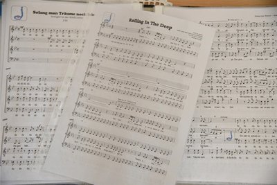 Ein Blick auf Noten von Popsongs, die der Wunschchor von Matthias Richter singt. Unter anderem hat der Chor Lieder von der Münchner Freiheit und Adele im Repertoire.