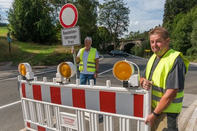 Bauleiter Lars Melzer (links) und Mitarbeiter Carsten Göbel heben die Vollsperrung an der Kniebreche auf. 