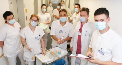 Nicolas Badora (r.) mit weiteren Azubis, Pflegekräften und Ärzten auf der Station 9 des Kreiskrankenhauses Freiberg. 