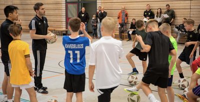 DFB-Stützpunkttrainer Marcus Sandig (2. v. l.) erklärt zum "DFB-Trainerdialog" vor den Augen regionaler Vereinstrainer zusammen mit Nam Ngo (l.) den mittelsächsischen Talenten die neuen Spielformate, die künftig noch stärker umgesetzt werden sollen. 
