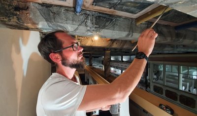Maler Christian Richter verleiht den erneuerten Balken an der Decke ein historisches Aussehen. 