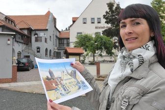 850 Jahre Freiberg: Hotelbranche profitiert von den Feierlichkeiten - Christine Walcha führt das neue Altstadt-Hotel an der Donatsgasse in Freiberg. Hier hält sie eine historische Aufnahme von dem Haus, die auch als Ansichtskarte erhältlich ist.