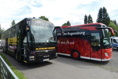 Die Busse von Dynamo Dresden und Jahn Regensburg auf dem Parkplatz der Arena zur Vogtlandweide in Auerbach.