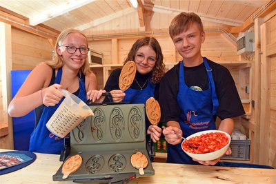 Melissa Wuttig, Anne Weber und Konstantin Weber (v.l.) beim Backen der Augustusburger Waffeln, die durch frische Erdbeerstückchen eine fruchtige Note bekommen.