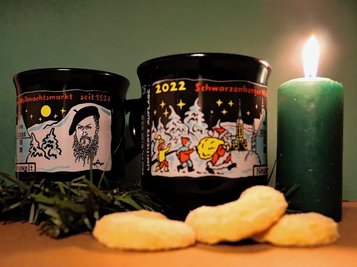 Das diesjährige Motiv der Weihnachtsmarkttasse: Neben dem obligatorischen Weihnachtsmann ist Ralf Alex Fichtner abgebildet. 