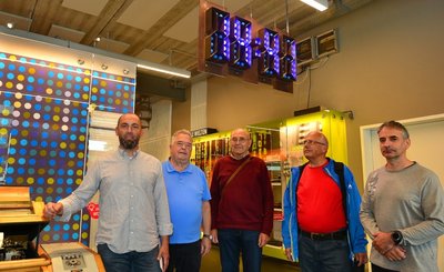 Museumsleiter Tobias U. Müller, Reiner Fucik und Gotthard Lehn vom früheren Uhrenwerk sowie die Helfer Joachim Graubner und Ronald Schuhmann (v. l.) vor der Digitaluhr im Museum Zeit-Werk-Stadt. 