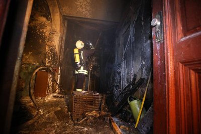 Mit einer Wärmebildkamera sucht ein Feuerwehrmann noch nach Brandherden in der Wand.