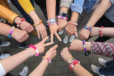Die Frauen der Selbsthilfegruppe bei einem Treffen mit selbst gebastelten Mut-Perlen-Armbändern