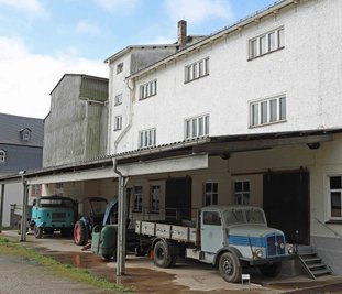 Die Schrotmühle öffnet erstmals für Besucher ihre Türen. Die Szene vor dem Objekt mit den parkenden Fahrzeugen wurde nachgestellt. Sie gehören zur Schau. 