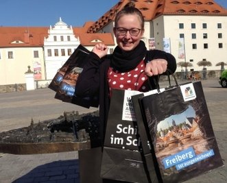 Die neuen Einkaufstüten, die ab sofort in Geschäften und der Tourist-Information zu haben sind, zeigtJanine Preißler, Mitarbeiterin im Amt Kultur-Stadt-Marketing.
