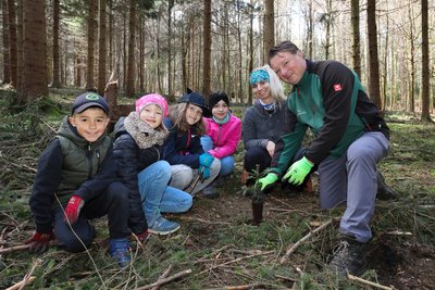 Henrik Lindner (r.), Geschäftsführer der Stiftung Wald für Sachsen, und Franziska Erlbeck, Leiterin des Waldschulheims Conradswiese, zeigten Paul, Anna, Ellie und Johanna wie ein Weißtanne gepflanzt wird.