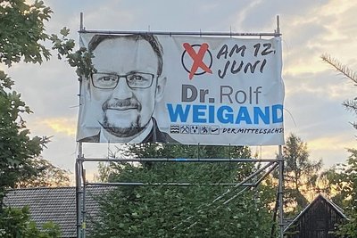 Das Transparent zur Landratswahl in Mittelsachsen am 12. Juni (zweiter Wahlgang am 3. Juli) von Rolf Weigand (AfD) hängt noch an der B 173 kurz nach dem Ortseingang aus Richtung Falkenau.