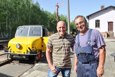 Dirk Kießling (links) und Thomas Krauß sind gut auf das Jubiläum vorbereitet. Der Schienentrabi steht startklar in Rochlitz.