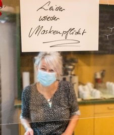 Im Bergamt auf der Großen Kirchgasse werden die Essensgäste mit einem Schild auf die neuen Regeln hingewiesen. Im Bild: Servicekraft Kerstin Reuter. 