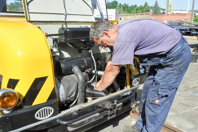 Thomas Krauß prüft, ob unter der Motorhaube des Schienentrabis alles in Ordnung ist. Mit den Bauteilen des Gleiskraftrades, die denen von Straßenfahrzeugen gleichen, kennt er sich gut aus.