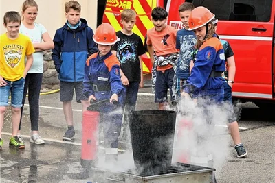 Alice und Finn von der Jugendfeuerwehr Böhrigen zeigen hier, wie man mit dem Feuerlöscher einen brennenden Papierkorb löscht.