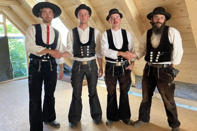 Die wandernden Zimmerer Paul (v.l.), Leonardo, Basti und Felix vor dem neuen Dachstuhl.