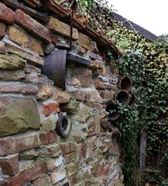Aus Abbruchsteinen und Rohren entstand diese dekorative Mauer.