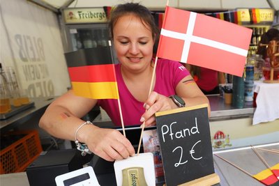 Neue Flaggen müssen her: Für Spiel 2 „hisst" Jessy Harwardt im Freiberger Schlosshof die Fahnen Deutschlands und Dänemarks.