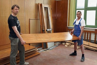 Christoph Kopp (links) und Jens-Uwe Dietze vom Verein "Wir in Werdau Süd" demontieren die hölzerne Wandverkleidung aus dem einstigen Mitropa-Saal. 