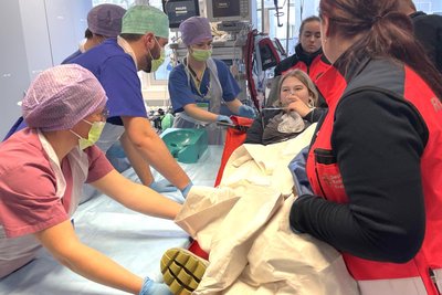 Die „Patientin“ wird gemeinsam von Rettungsdienst und Klinikpersonal in Freiberg von der Rettungsliege auf eine Behandlungsliege umgebettet.