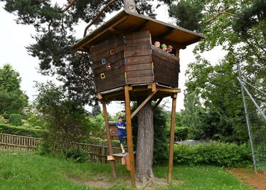 Auf das Baumhaus im Garten der Auer Kindertagesstätte "Spatzennest" hinauf dürfen immer nur drei Kinder - zwei, Emely Schreiber und Devin Leng (von links), sind schon oben mit Hausmeister Andreas Stief. An der Leiter unten wartet noch Nicholas Kropp. 