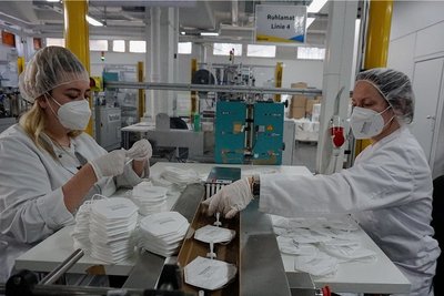 Luisa Händel (links) und Schichtleiterin Kerstin Lehmann (rechts) bereiten die FFP2-Masken für den Verpackungsprozess vor.