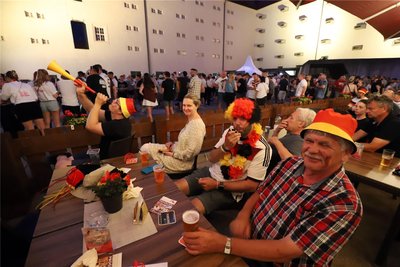 Felix John (l.), Hansi John und Marcel Dreyer (v.r.) bewahren sich beim Public Viewing im Schlosshof Freiberg ihre gute Laune.