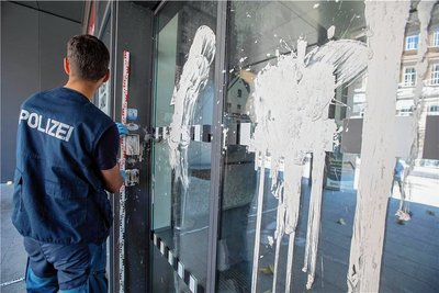Die Eingangstür des Plauener Landratsamtes am Postplatz ist über und über mit weißer Farbe beschmiert. Die Polizei dokumentiert das Geschehen.