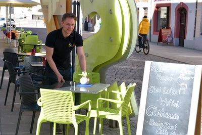 Am Café im Studieninformationszentrum (im Bild SIZ; Betriebsleiter Dominik Kleist) in der Burgstraße gibt es schon Außengastronomie. Gegen die niedrigen Temperaturen liegen Kissen und Decken bereit.