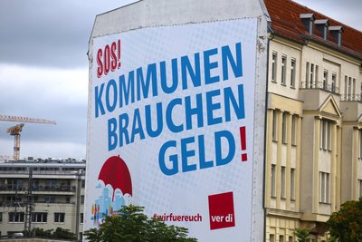 „SOS! Kommunen brauchen Geld!“: Ein Plakat der Gewerkschaft Verdi an einem Wohnhaus in Berlin. Auch in Sachsen pfeifen viele Städte, Gemeinden und Landkreise finanziell auf dem letzten Loch.