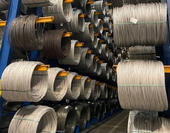 Blick ins Lager mit dem Vormaterial, im Bild sind Walzdrahtringe zu sehen. Diese werden in Lugau durch mehrere Zieh- und Glühoperationen veredelt. Aus ihnen werden später beispielsweise Achsen, Wellen oder Schrauben.
