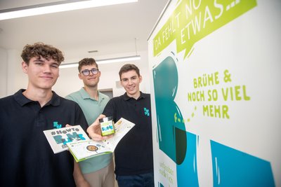 Mit T-Shirts, Plakaten und kleinen Kochbüchern sind die drei Geschäftsführer der Gemüsepaste „Bums“ gut am Start.