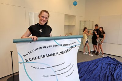 Museumsmitarbeiterin Sindy Nagy mit einem Plakat zur Sonderausstellung.