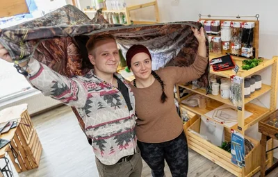 Patrick Leonhardt und Laura Knape mit dem Tarp, das man zum Übernachten im Wald aufspannen kann. 
