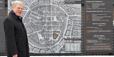 Georg Unland im Hof des Hörsaalzentrums Prüferstraße am historischen Freiberger Stadtplan mit von ihm entworfenen Texten. 