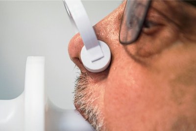 Symptom Luftnot: Ein Long-Covid-Patient lässt seine Lungenfunktion mit einem Bodyplethysmographen überprüfen.