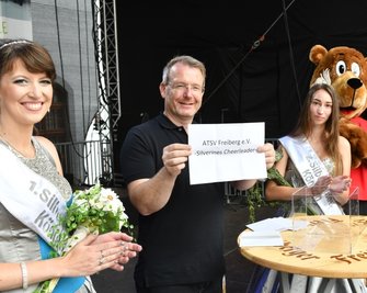 Die scheidende Silberstadtkönigin Julia I. (l.), ihre Nachfolgerin Celine I. und Oberbürgermeister Sven Krüger losen den Gewinner der Vereinstombola aus.
