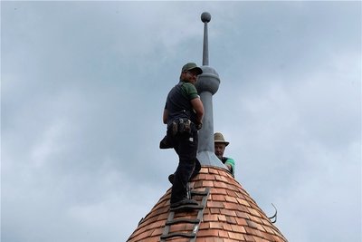 Tobias und Ulf Voit vom gleichnamigen Dachdecker-Fachbetrieb in Netzschkau befestigen die Spitze mit der Kapsel auf dem untersten Turm der Elsterberger Burgruine. 