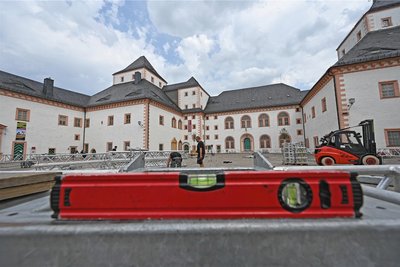 Alles muss stimmen: Mit Wasserwaage und Laser sorgte das Aufbauteam dafür, dass das monumentale Zelt auf dem Steinboden des Schlosshofs gerade steht.