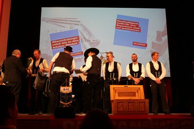 Sie fallen auf – junge Zimmerer in ihrer Tracht. Sie erhielten im Kulturhaus in Aue ihr Zeugnis und sind nun Gesellen, vorn die Innungslade.