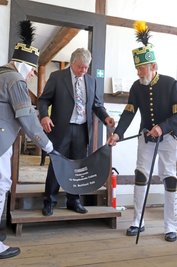 Burkhard Pohl (M.) bereitet sich auf seinen Ehrenarschledersprung vor. Ein Arschleder, das bei der Arbeit im Bergbau das Hinterteil der Bergleute schützte, ist ein wesentliches Zubehör der traditionellen Bergleute. Mit dem Arschledersprung erwirbt man sich die Ehre, die Lederschürze bei offiziellen Anlässen der Knappschaften zu tragen.