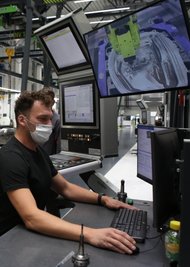 So sieht der Arbeitsplatz eines Zerspanungsmechanikers bei Porsche aus: Erik Schmiedel steuert per Computer eine hochmoderne Fräsmaschine, die eine Tür bearbeitet.