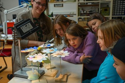 Schüler der Pablo-Neruda-Grundschule bastelten unter Anleitung von Mitarbeitern wie Tina Gräßler (links) eine Blume, die sich mit Solarenergie in Bewegung setzt. 