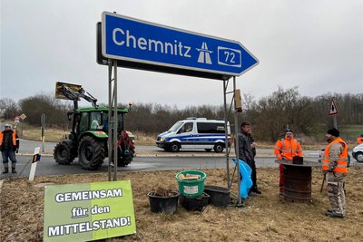 Protestierende wärmen sich an einer der Feuertonnen.