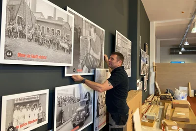 Ingolf Eckardt vom gleichnamigen Montageservice arbeitet an der Foto-Wand.